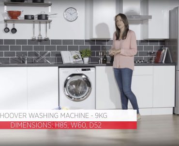 Women presenting the Hoover DXOA49C3 in white and grey kitchen